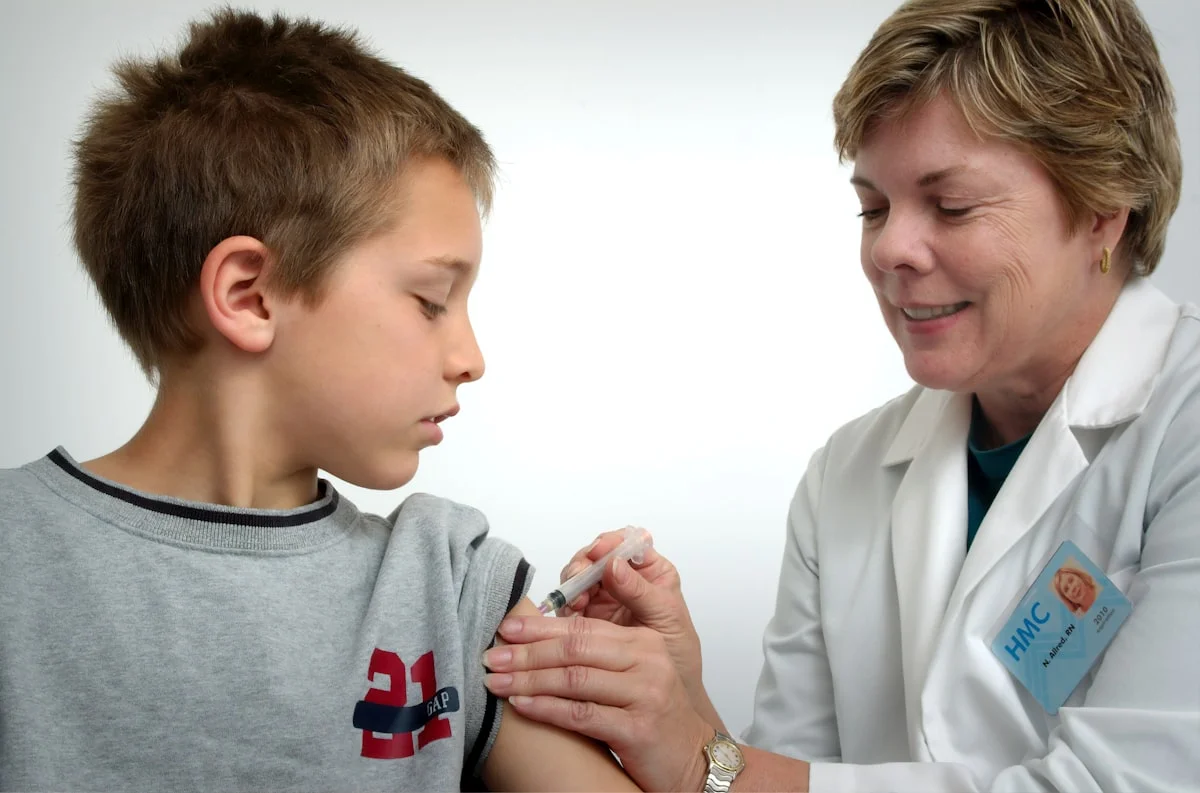pediatrician near me accepting new patients - The nurse depicted in this 2006 photograph was in the process of administering an intramuscular vaccination in the left shoulder of a young boy. The nurse was pinching the overlying shoulder skin, in order to immobilize the injection site.